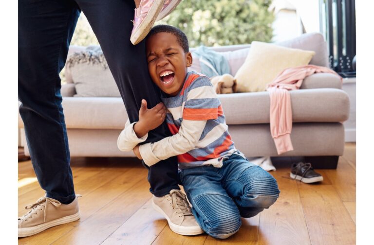 A young child throwing a tantrum on the floor, looking upset and frustrated.